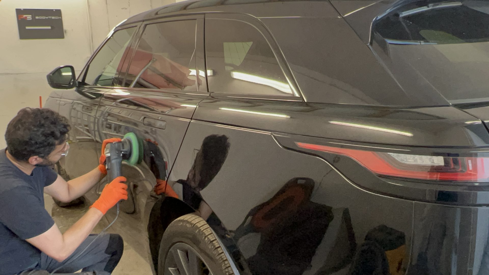 Man polishing black car's side meticulously