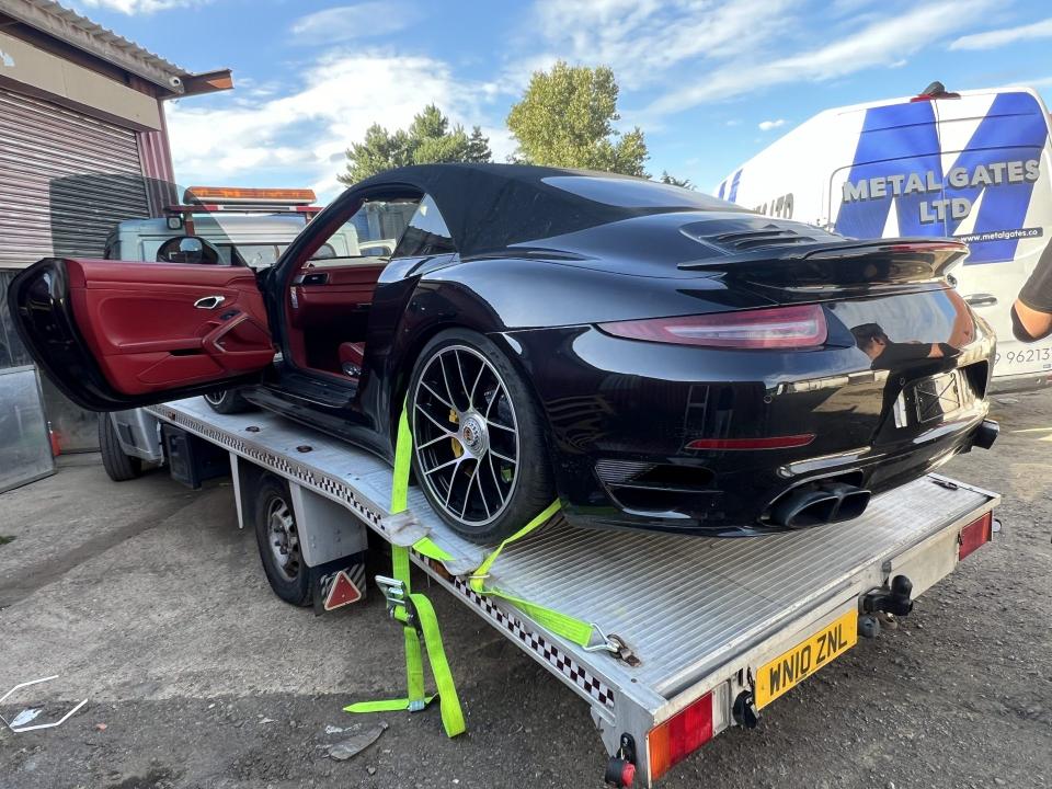 Black sports car loaded onto tow truck