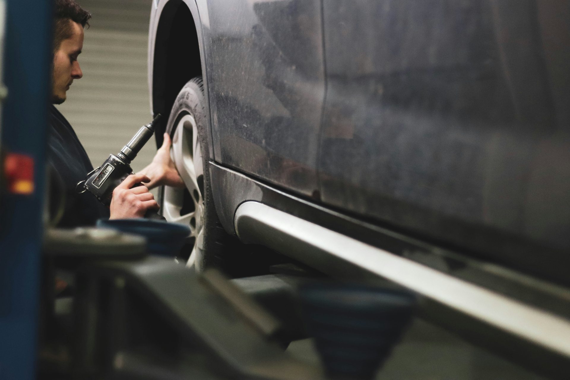 Mechanic working on car wheel alignment